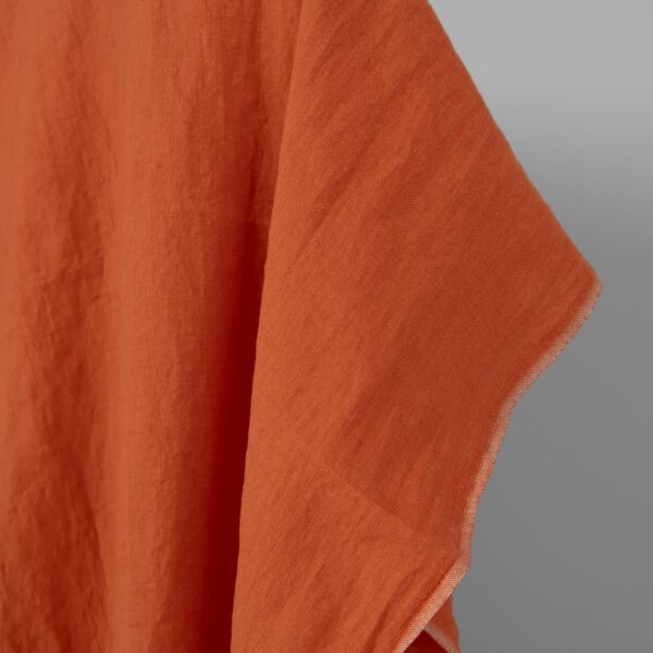 Washed linen fabric in dark orange, fabric edge