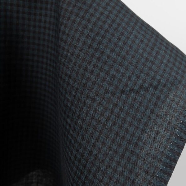 Dark linen fabric in black and blue checks close up edge view