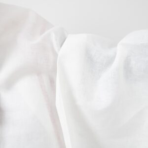 Valkoinen pellavakangas punaisilla viivoilla