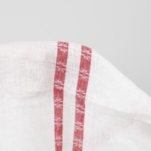 Valkoinen pellavakangas punaisilla viivoilla