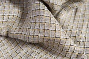 Pellavanharmaa kangas keltaisilla ruuduilla, pesty