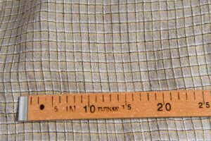 Pellavanharmaa kangas keltaisilla ruuduilla, pesty