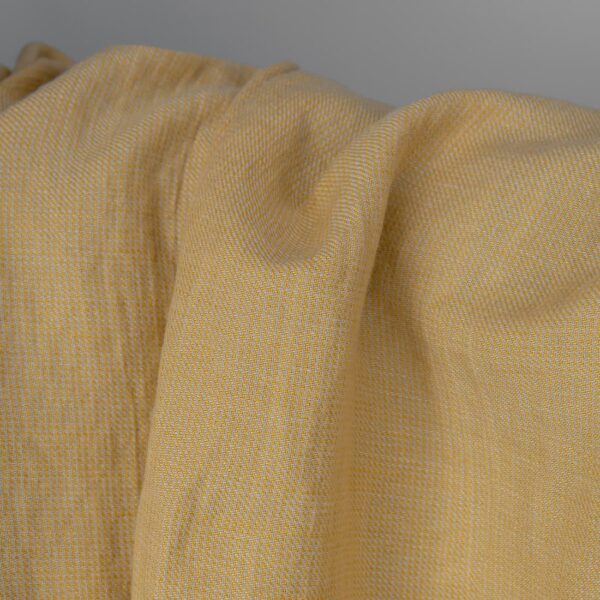 Washed linen cotton fabric in yellow-sand small pattern close up detail