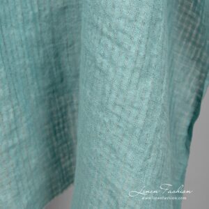 Sinivihreä pellavakangas läpikuultavilla ruuduilla pesty